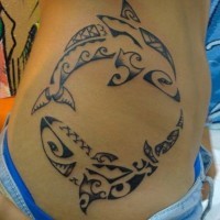Tatuaje en el costado, dos delfines tribales, tinta negra