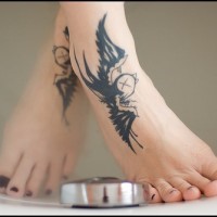 Tatuaggio sui piedi due rondini nere volano