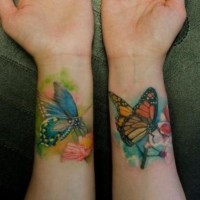 Tatuaje en las muñecas, 
mariposas hermosas en la rama y flor