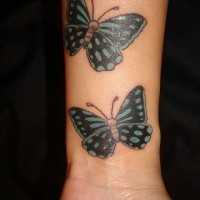 due carine farfalle verde tatuaggio disegno su polso