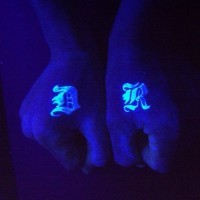 Tatuaje en las manos, dos letras, tinta ultravioleta