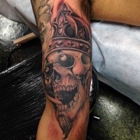 Typical black and gray style arm tattoo of skull with crown
