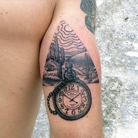 Typical black and gray style arm tattoo of triangle shaped desert picture and old clock