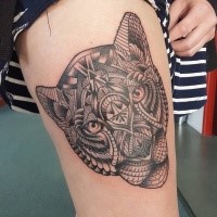 Typical black and gray style thigh tattoo of lion head stylized with various ornaments