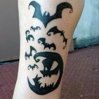 Typical black and white leg tattoo of monster moon with bats