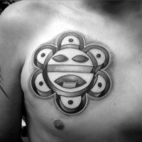 Typical black ink chest tattoo of small Aztec sun