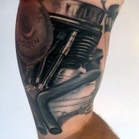 Typical black ink detailed engine tattoo on arm