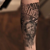 Typical black ink famous actor portrait tattoo stylized with lettering
