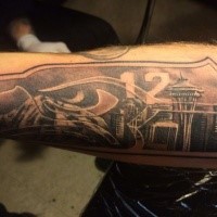 Typical black ink forearm tattoo of city sights and number