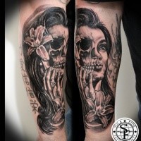 Typical black ink forearm tattoo of half skull half woman face tattoo with flower