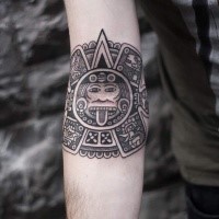 Typical black ink forearm tattoo of Mayan tablet