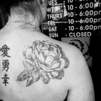 Typical black ink linework style scapular tattoo of big rose