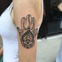 Typical black ink shoulder tattoo of Hamsa symbol stylized with ornaments
