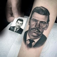 Typical colored portrait style forearm tattoo of man face