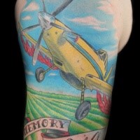 Typical illustrative style shoulder tattoo of little plane with lettering