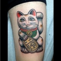 Typical painted and colored thigh tattoo of maneki neko japanese lucky cat with necklace