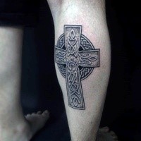 Typical very detailed leg tattoo of Celtic cross