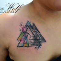 Typical watercolor style small mystic symbol tattoo on chest