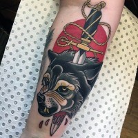 Tatuaje colorido en el antebrazo, lobo furioso perforado por daga
