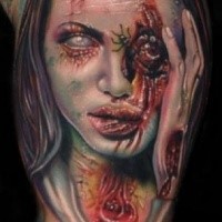 Unglaublich aussehendes farbiges im Horror Stil sehr detailliertes Bizeps Tattoo mit Zombie Frau Gesicht