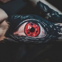 Gruseliges großes schwarzes Auge mit einer roten Pupille Tattoo am Arm von Megan Allard