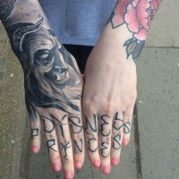 Einzigartiges schwarzes und weißes fantstisches Monster Gesicht Tattoo an der Hand mit Schriftzug