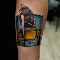 Unique designed 3D like colored whiskey glass tattoo on forearm stylized with sailing ship
