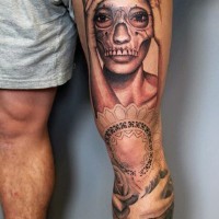 Einzigartiges schwarzweißes Porträt der Frau mit dem Schädel-Maske Tattoo am Oberschenkel
