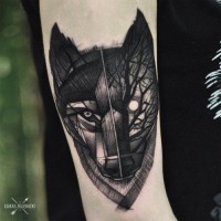 Unique painted black ink wolf face tattoo on forearm stylized with night forest