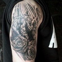 Tatuaje  negro blanco de ángel misterioso con flores en el brazo