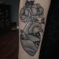 Ungewöhnliches schwarzes Oldschool Herz Tattoo am Unterarm mit Fisch und Blumen