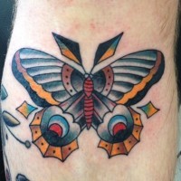 Unusual colored moth tattoo on mans leg