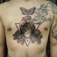 Tatuaje en el pecho, corazón humano con plantas y polilla