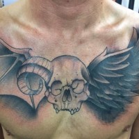 Tatuaje en el pecho,  cráneo humano con cuerno y alas de murciélago y cuervo