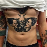 Unusual designed black ink big night butterfly tattoo on chest stylized with human skull and antic movie heroes