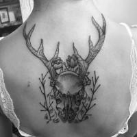 Tatuaje en la espalda, cráneo gris espectacular con flores diminutas