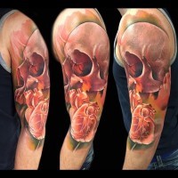 Unusual nice colored skull tattoo on shoulder with human heart