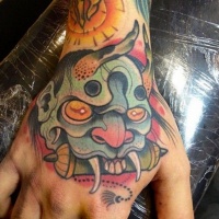 Usual Asian style painted on hand colored tattoo of demonic face