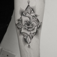 Tatuaje en el antebrazo, flor bonita gris en figura geométrica