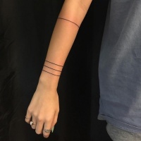 Usuale tatuaggio dell'avambraccio nero inchiostro di linee nere parallele