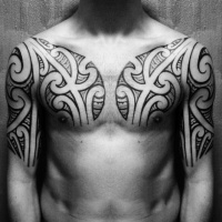 Usual black ink tribal style tattoo on chest and upper arm