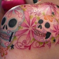 Tatuaje en el hombro, calaveras de azúcar bonitos entre flores preciosas