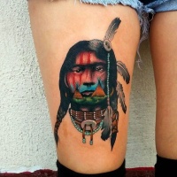Usual painted and colored thigh tattoo of Indian man face stylized with houses