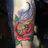 Usual painted red colored rose flower tattoo on forearm stylized with quidditch ball