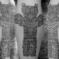 Usual style black and white tribal Gods statue tattoo on leg