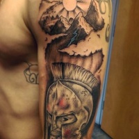 Tatuaje en el hombro,
cabeza de guerrero espartano  con montañas y sol, colores negro blanco