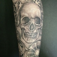 Usual style painted big skull with flowers tattoo on arm