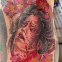 Usual terrifying colored severed head of Asian woman tattoo stylized with flowers