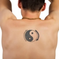 Tatuaggio piccolo sulla schiena il disegno nero in stile Yin-Yang