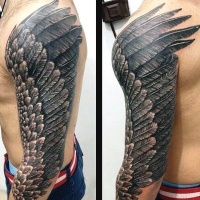 Very beautiful looking black and white bird wing tattoo on sleeve